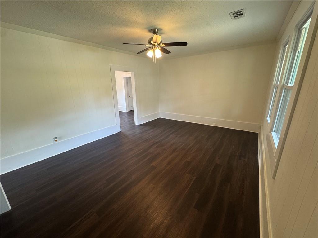 24 Lower Street Valley, AL 36854 - Photo 2 of 18 Empty room featuring dark wood finished floors, a textured ceiling, and a ceiling fan