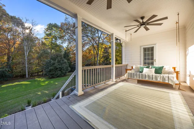 a balcony with wooden floor table and chairs