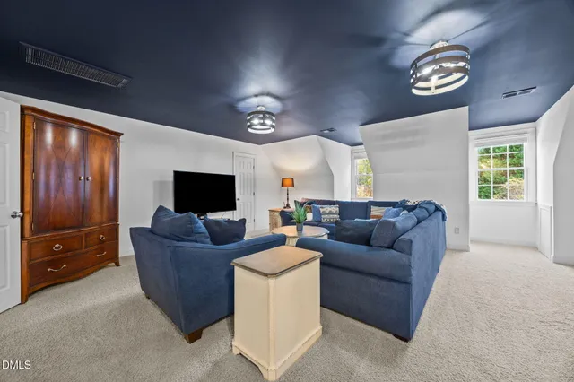 a living room with stainless steel appliances kitchen island furniture and a ceiling fan