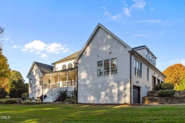 a view of a house with a yard and sitting area