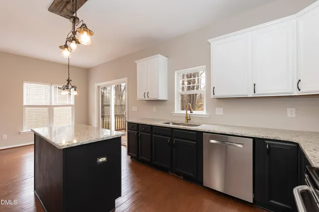 a kitchen with granite countertop white cabinets and sink