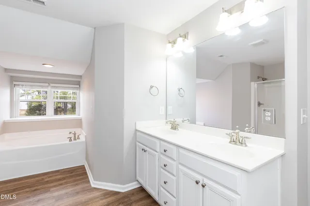 a bathroom with a sink double vanity granite tub and a mirror