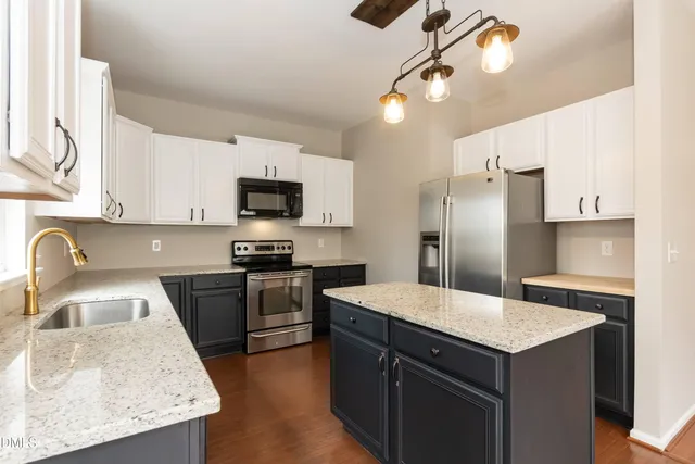 a kitchen with a sink a center island and stainless steel appliances