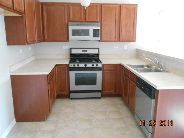 4425 Timber Ridge Court, Unit 117 Joliet, IL 60431 - Photo 5 of 10 a kitchen with a sink stove and cabinets
