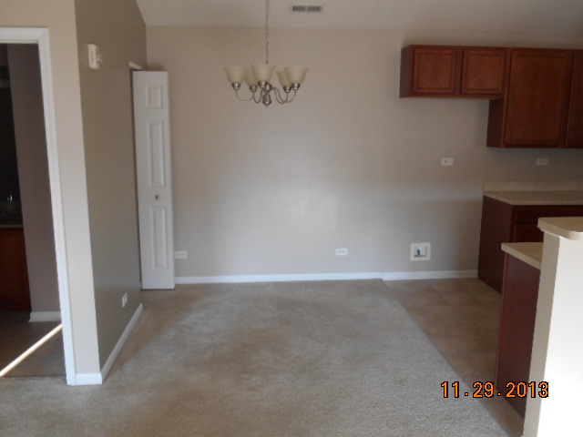 4425 Timber Ridge Court, Unit 117 Joliet, IL 60431 - Photo 7 of 10 an empty room with a fireplace