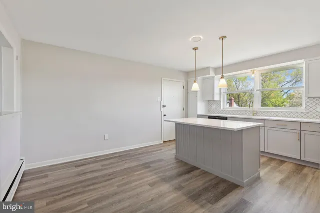 a large kitchen with kitchen island white cabinets and wooden floor