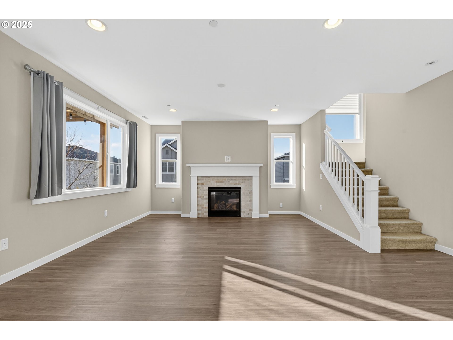 9863 Southwest Ridge Drive Beaverton, OR 97007 - Photo 5 of 48 a view of an empty room with wooden floor fireplace and a window