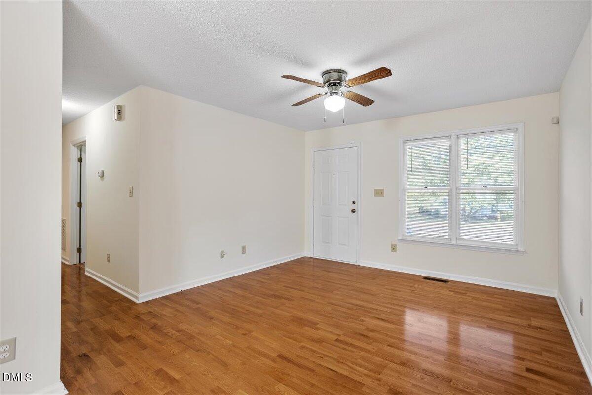 4208 Bluewing Road Raleigh, NC 27616 - Photo 8 of 21 a view of empty room with wooden floor and fan