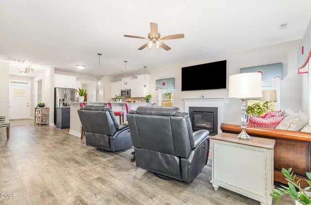 a living room with furniture a fireplace and a flat screen tv