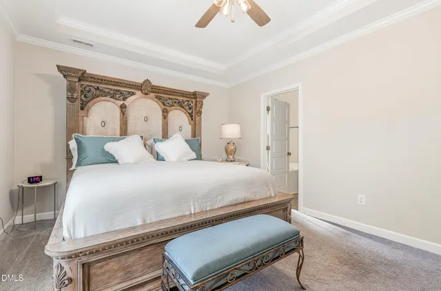 a spacious bedroom with a bed a dresser and windows