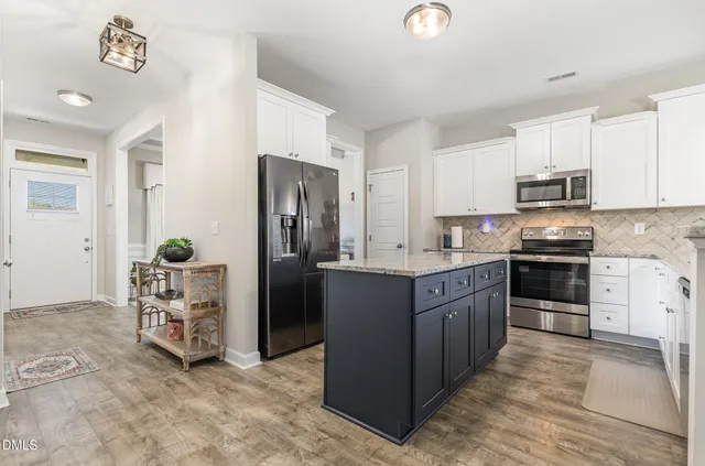 a kitchen with stainless steel appliances granite countertop a refrigerator and a stove top oven