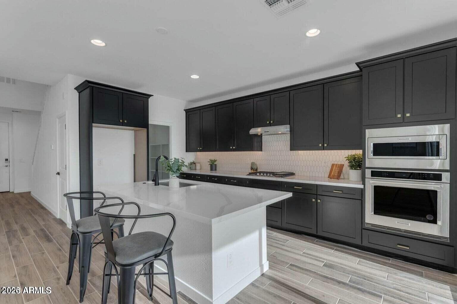 6434 North 17th Street Phoenix, AZ 85016 - Photo 11 of 38 a kitchen with stainless steel appliances kitchen island granite countertop a stove a sink and a microwave