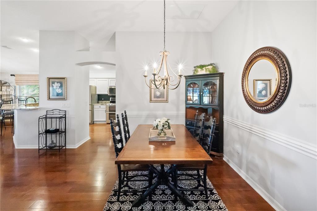 1456 Honea Path The Villages, FL 32162 - Photo 13 of 44 a dining room with wooden floor a glass table and chairs