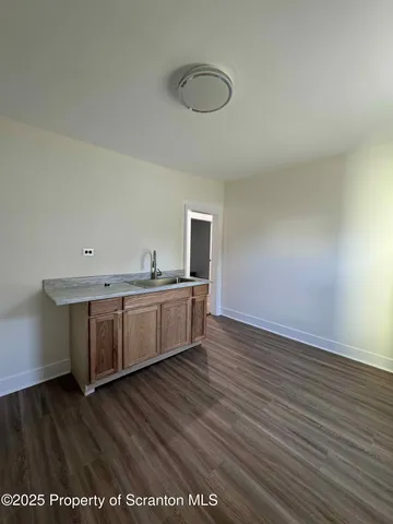 a view of a kitchen with wooden floor and a sink