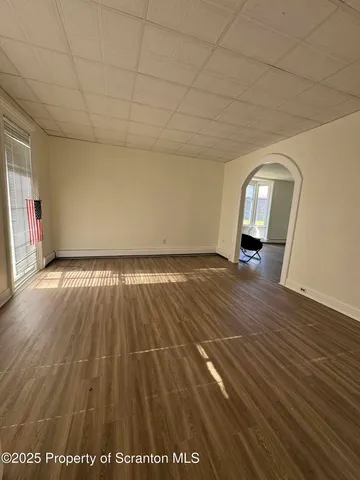a view of empty room with wooden floor