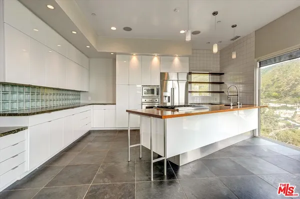 a large white kitchen with a large window
