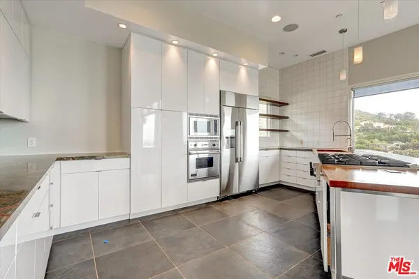 a view of kitchen with stainless steel appliances cabinets and outdoor space