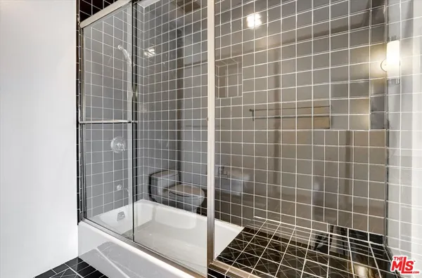 a bathroom with a granite countertop sink a large mirror and shower
