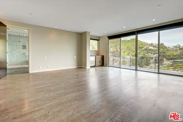 a large kitchen with kitchen island granite countertop a large window a sink and cabinets