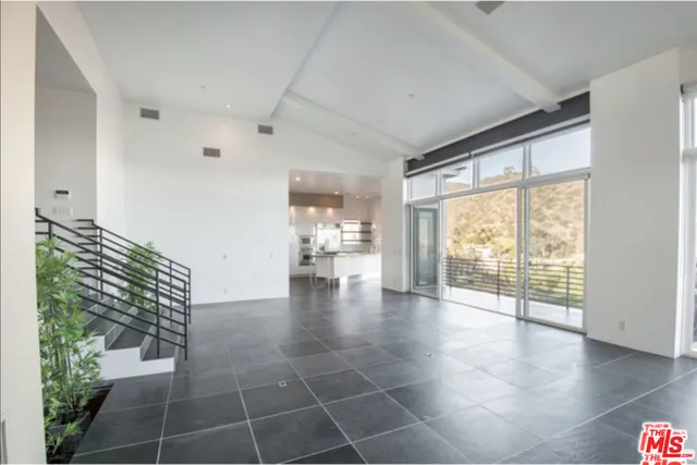 a view of a hallway with wooden floor and a living room