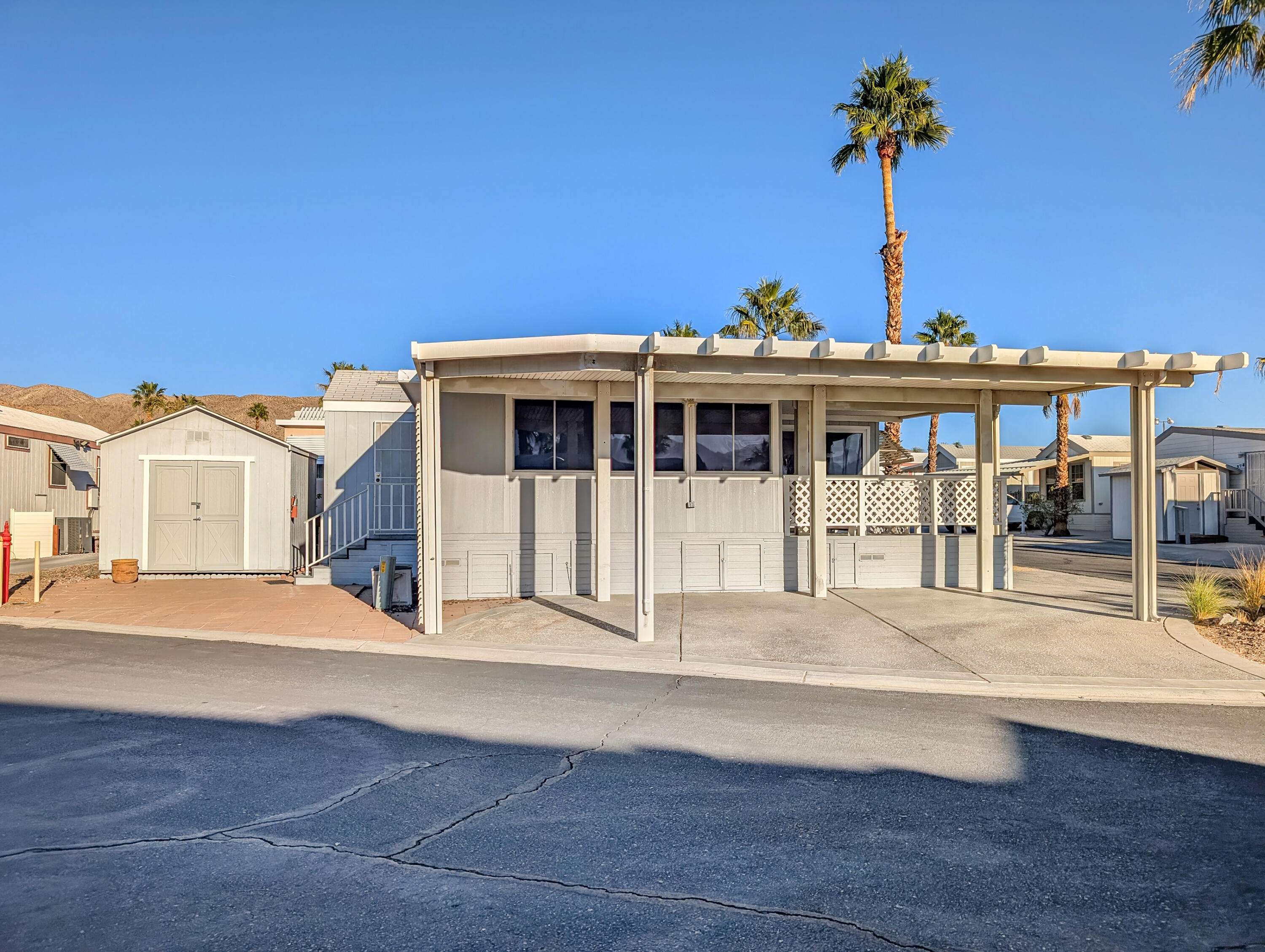 70200 Dillon Road, Unit 517 Desert Hot Springs, CA 92241 - Photo 5 of 32 a front view of a building with a garden and yard