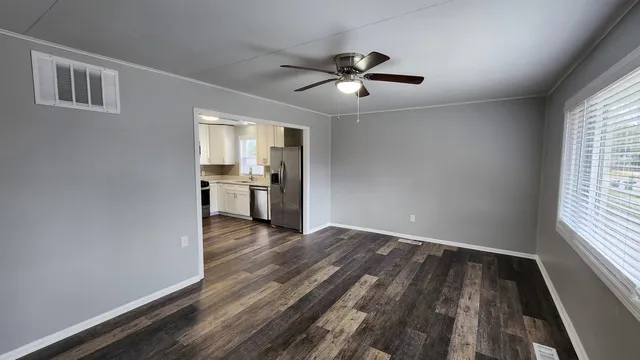 a view of empty room with wooden floor and window
