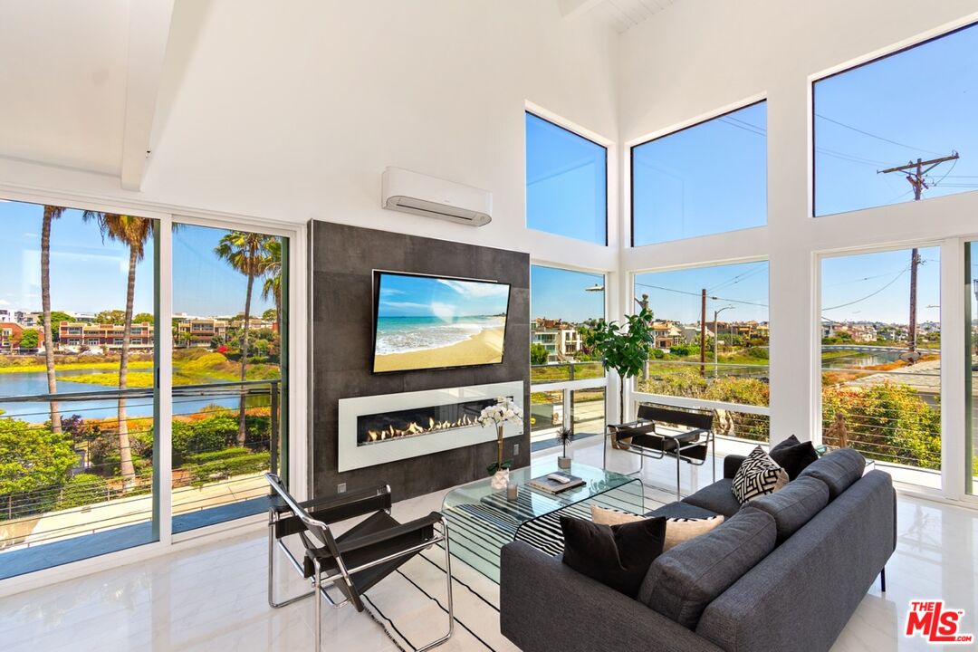 a living room with furniture a floor to ceiling window and a flat screen tv