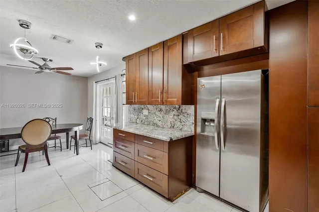 a kitchen with granite countertop cabinets and refrigerator