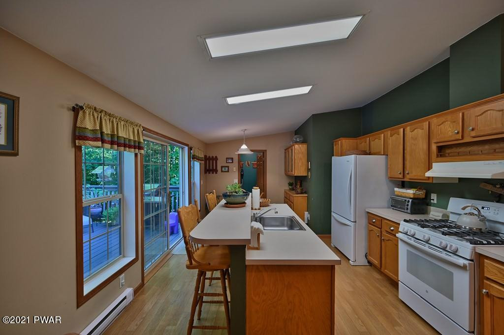 417 Northgate Road Lake Ariel, PA 18436 - Photo 14 of 91 a kitchen with stainless steel appliances granite countertop a refrigerator a sink dishwasher a stove and a dining table with wooden floor