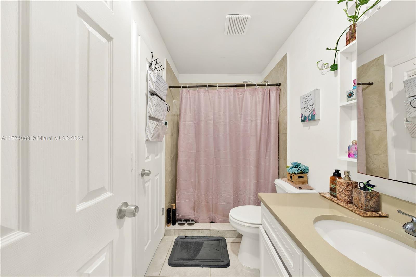 10810 Northwest 7th Street, Unit 6B Miami, FL 33172 - Photo 14 of 19 a bathroom with a sink a toilet and shower curtain