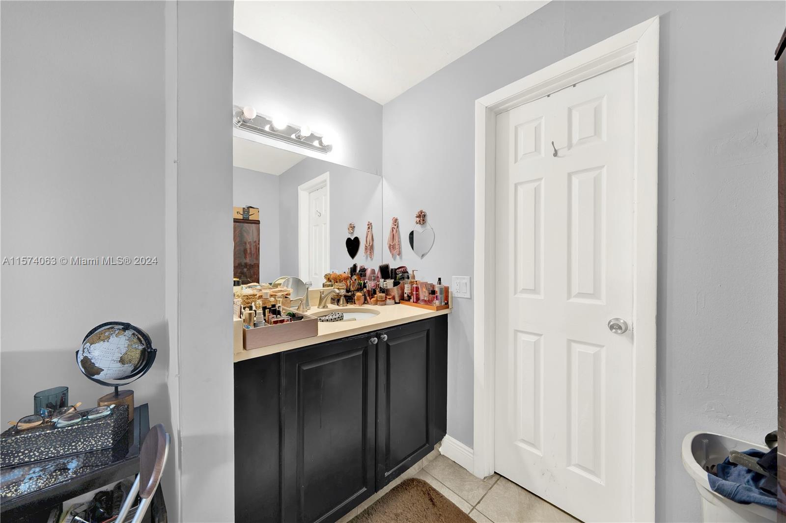 10810 Northwest 7th Street, Unit 6B Miami, FL 33172 - Photo 16 of 19 a bathroom with a sink and a mirror