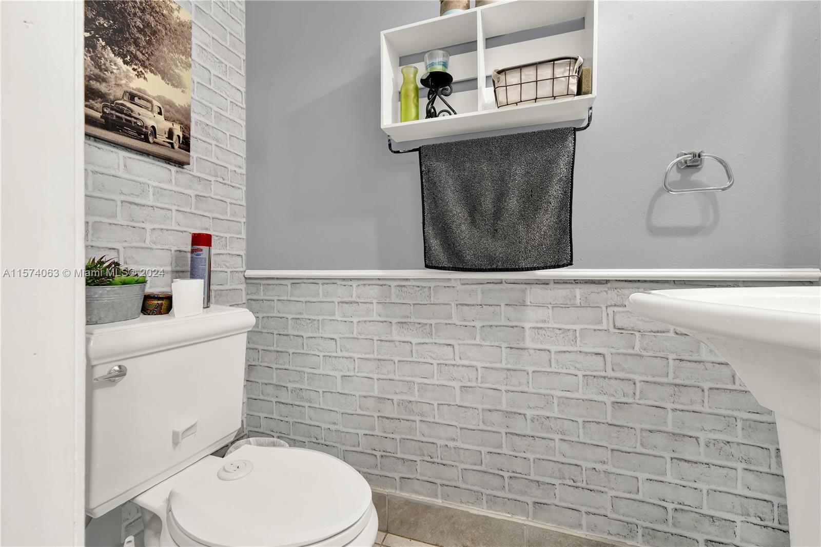 10810 Northwest 7th Street, Unit 6B Miami, FL 33172 - Photo 17 of 19 a bathroom with a toilet sink and mirror