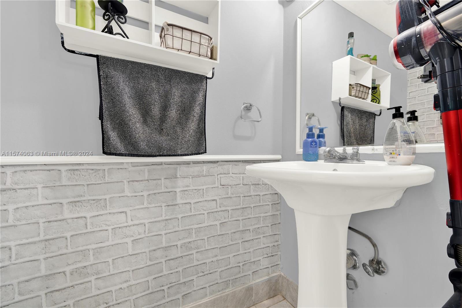 10810 Northwest 7th Street, Unit 6B Miami, FL 33172 - Photo 18 of 19 a bathroom with a sink and a mirror