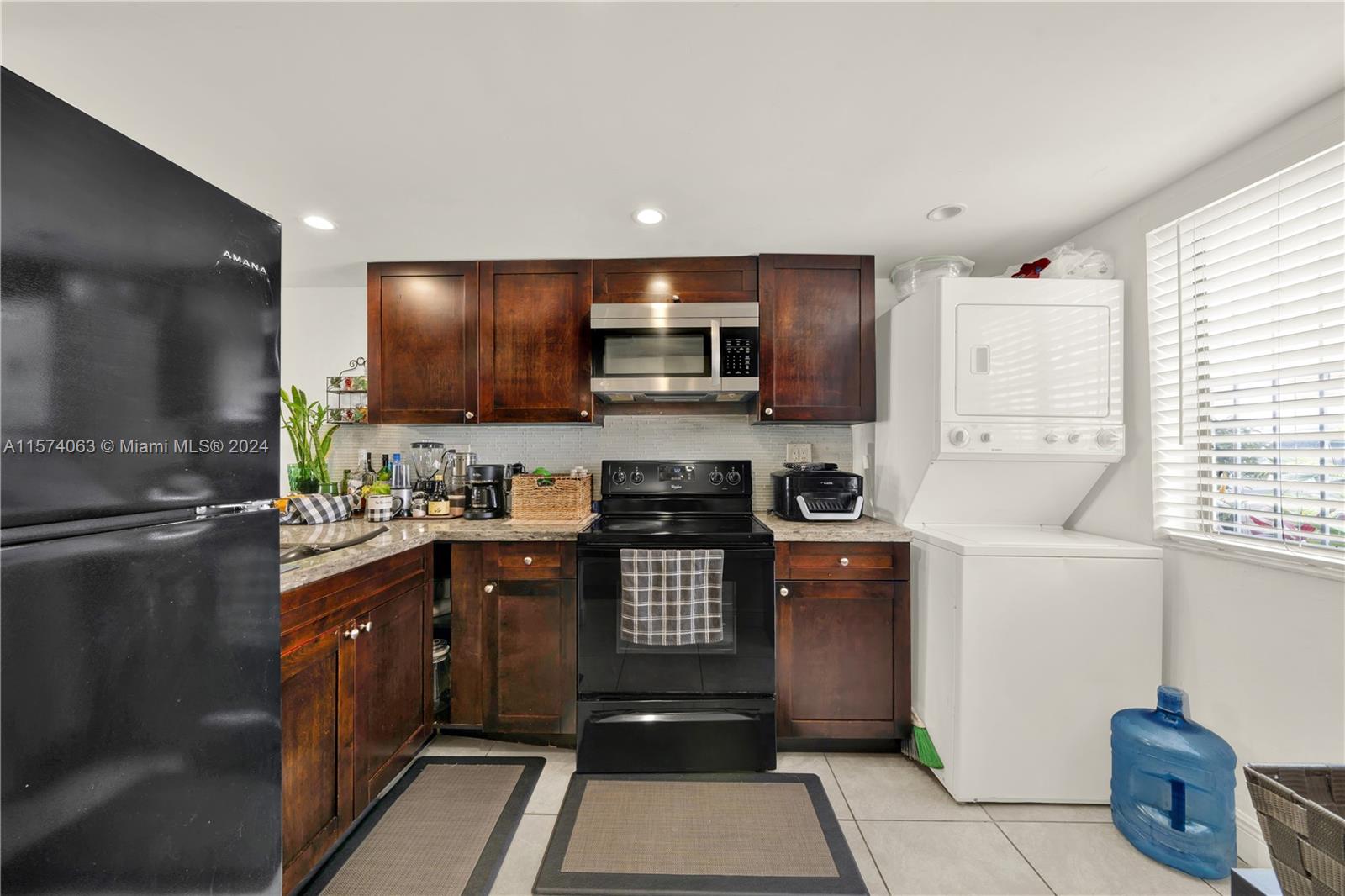 10810 Northwest 7th Street, Unit 6B Miami, FL 33172 - Photo 7 of 19 a kitchen with stainless steel appliances granite countertop a stove a sink and a refrigerator
