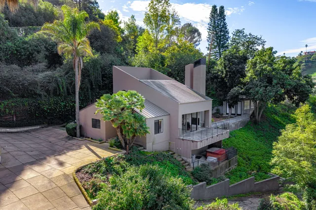 a view of a house with a yard and potted plants