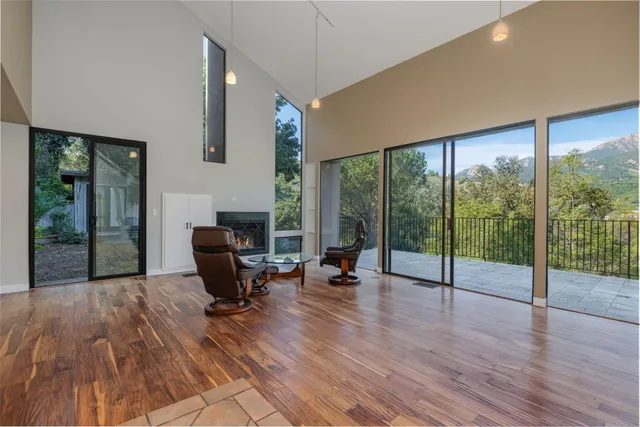 a living room with furniture floor to ceiling window and wooden floor