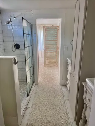 a bathroom with a glass door shower and a sink