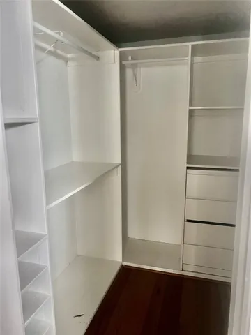 a view of walk in closet with empty racks