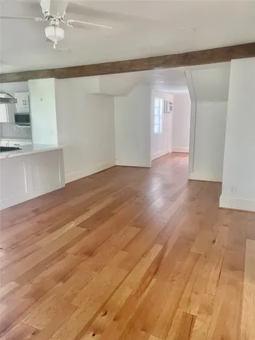 a large kitchen with kitchen island a stove a sink dishwasher and a refrigerator with wooden floor