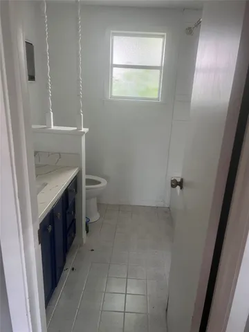 a bathroom with a sink toilet and window