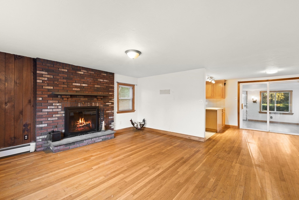 53 Forge Road Assonet, MA 02702 - Photo 4 of 39 a view of empty room with wooden floor and fireplace