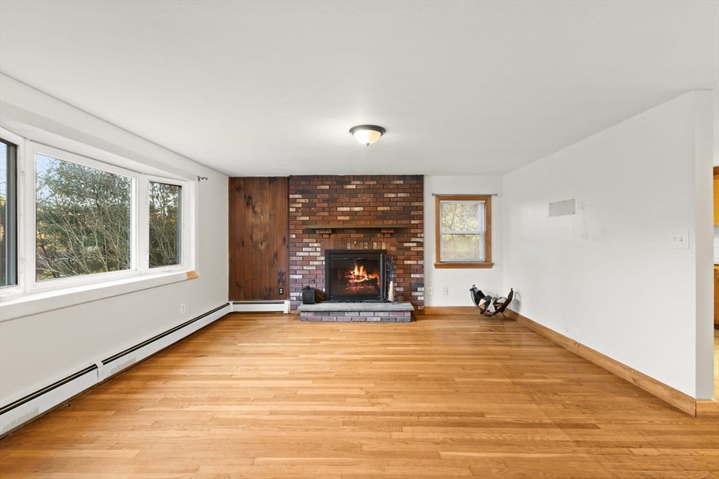 53 Forge Road Assonet, MA 02702 - Photo 5 of 39 a view of an empty room with a fireplace and a window