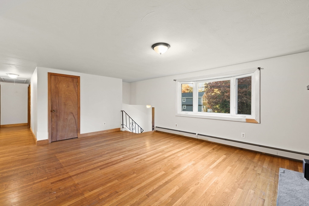 53 Forge Road Assonet, MA 02702 - Photo 6 of 39 a view of an empty room with wooden floor and a window