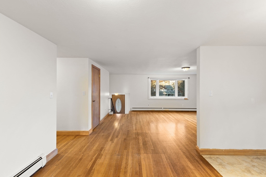 53 Forge Road Assonet, MA 02702 - Photo 9 of 39 a view of an empty room with wooden floor and a window