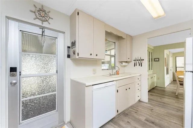 a kitchen with a sink cabinets and wooden floor