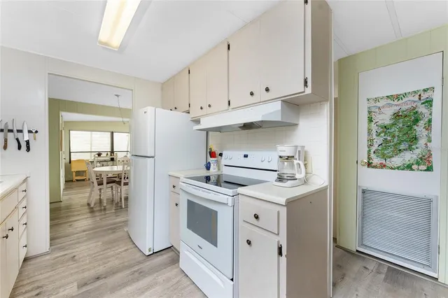 a kitchen with white cabinets and white appliances
