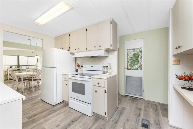 a kitchen with white cabinets and white appliances