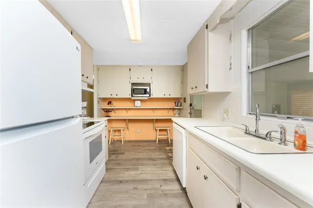 a kitchen with a sink stove and white cabinets