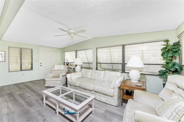 a living room with furniture a table and a large window