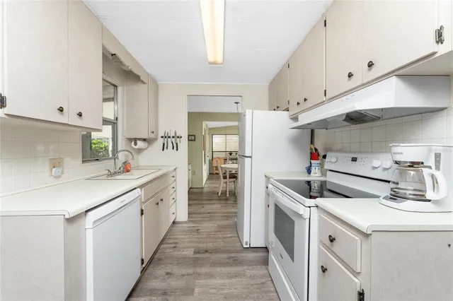 a kitchen with stove a sink and cabinets